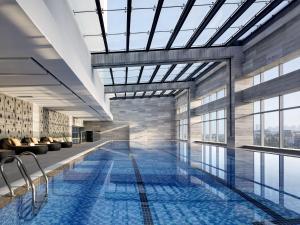 廈門的住宿－廈門朗豪酒店，一座带玻璃天花板的建筑中的游泳池