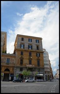 un grand bâtiment avec des voitures garées devant lui dans l'établissement Lilium Boutique Hotel, à Rome