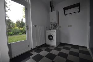 a laundry room with a washing machine and a window at Vakantiewoning nabij Toverland in Griendtsveen