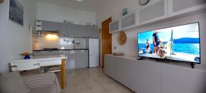 a kitchen with a flat screen tv on a wall at Casa di Marco Independent apartment with spectacular view in Cala Gonone