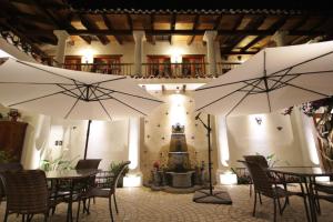 twee witte parasols in een kamer met tafels en een fontein bij HOTEL PROVINCIA in San Cristóbal de Las Casas