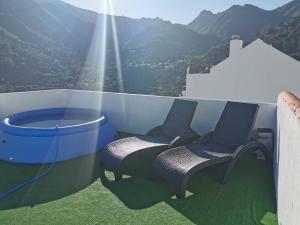2 stoelen en een bad op een balkon met bergen bij Habitación junto el mar y la naturaleza in Ojén