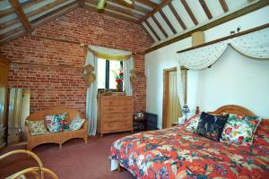 a bedroom with a bed and a brick wall at Hilltop Barn in Blandford Forum