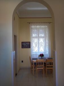 a dining room with a table and chairs and a window at Via Tokaj Vendégház in Sátoraljaújhely