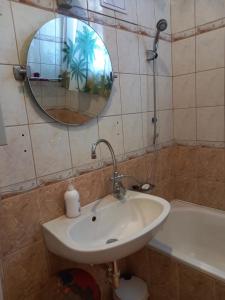 a bathroom with a sink and a mirror and a tub at Via Tokaj Vendégház in Sátoraljaújhely