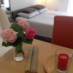 eine Vase mit rosa Blumen auf einem Tisch in der Unterkunft Apartman Mona in Mostar