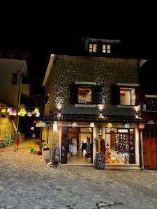 ein Geschäft vor einem Backsteingebäude in der Nacht in der Unterkunft Iguana House in Stari Bar