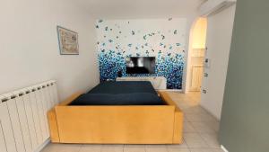 1 dormitorio con 1 cama y TV en la pared en Ca'Vio Beach & Pool, en Cavallino-Treporti