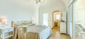 a white bedroom with a bed and a window at Villa DAlessandro in Anacapri