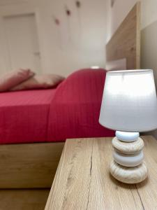 een witte lamp op een houten tafel in een slaapkamer bij La Casa di Nonna Nina in Carovigno
