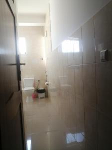 a white bathroom with a toilet and a sink at Apartamento Casa hollanda in Mindelo