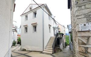 Un escalier mène à un bâtiment blanc. dans l'établissement Apartment D & Studio L, à Dobrinj
