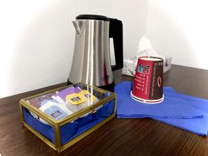a coffee maker and a thermos on a wooden table at Hotel Hamburg Inn Free Parking in Hamburg