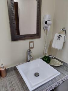 a white sink in a bathroom with a mirror at Hostería Tocali in Tlaxcala de Xicohténcatl