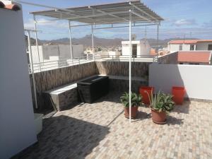 a rooftop patio with awning on top of a building at Apartamento Casa hollanda in Mindelo