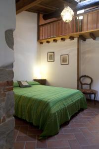 1 dormitorio con 1 cama con manta verde en All'Antico Silbule en Capolona