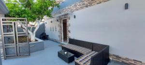eine Terrasse mit einer Bank und einem Tisch auf einem Gebäude in der Unterkunft Litsa Galaxy Apartment in Artemida
