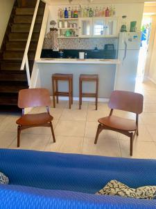 a living room with two chairs and a kitchen at Boutique-Apartamento Vidabuena Buzios - MYNAPARTAMENTOS in Búzios
