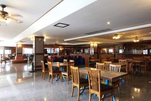 a restaurant with wooden tables and chairs and a bar at The A.A. Pattaya Residence in Pattaya Central
