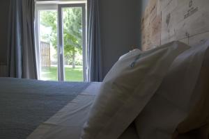 a bedroom with a white bed with a window at D'Vine - Country house in Cartaxo