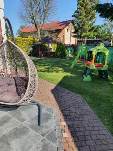 un columpio en un patio con parque infantil en Willa Samana Pokoje, en Dziwnówek