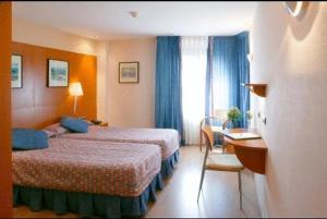 a hotel room with two beds and a desk at Hotel Restaurante Salvadora in Villena