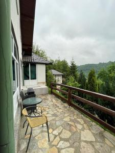 een patio met een tafel en stoelen op een balkon bij Villa Nature in Bihać