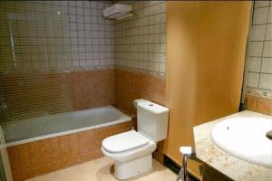 y baño con aseo, bañera y lavamanos. en Hotel Restaurante Salvadora, en Villena