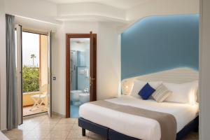 a bedroom with a large bed and a bathroom at Hotel Casa Yvorio in Terracina