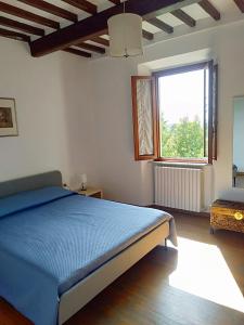 a bedroom with a blue bed and a window at La casa di Elisa in Vinci