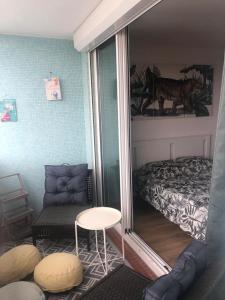una camera con letto, sedia e specchio di Appartement 5 étoiles charmant et cosy a Canet-en-Roussillon