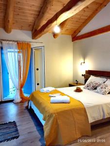 a bedroom with a large bed and a large window at Spiro's cottage in Vlachopoulátika