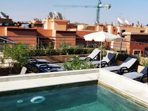 uma piscina com cadeiras e um guarda-sol num telhado em Stars Hotel & Spa em Marrakech