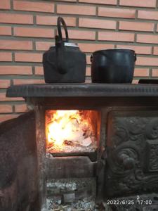 a stove with a pot and a fire at Casa Refúgio e Aconchego in Igrejinha