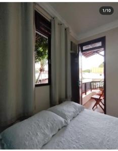 ein Schlafzimmer mit Bett, Fenster und Balkon in der Unterkunft Pousada Flor D' Açucena in Natal + 88 Fotos