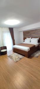 a bedroom with a large bed with a wooden headboard at Pensiunea Antonio Bran in Bran +71 photos