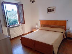 a bedroom with a bed and a large window at La casa di Elisa in Vinci