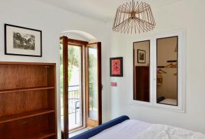 a bedroom with a bed and a chandelier at casa prima vista in Torri del Benaco