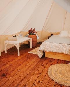 a room with a tent with a bed and a table at Rubeni in Stāķi