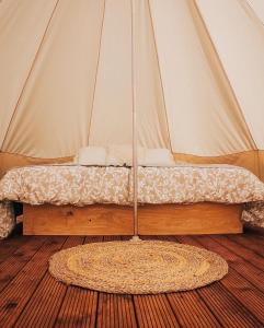 a bed in a tent with a rug in a room at Rubeni in Stāķi