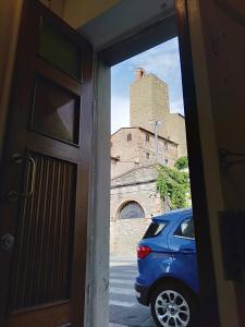 a door view of a building and a blue car at La casa di Elisa in Vinci