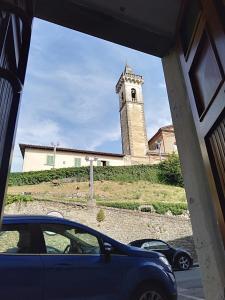 une voiture garée devant un immeuble avec une tour d'horloge dans l'établissement La casa di Elisa, à Vinci