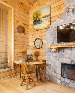 a dining room with a stone fireplace in a log cabin at Retro Suites Hotel in Chatham