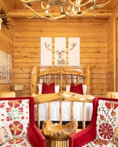 Dormitorio en cabaña de madera con 1 cama y 2 sillas en Retro Suites Hotel, en Chatham