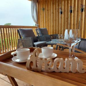 een houten tafel met een bord met koffie en glazen bij Mobilehome LUNA Selce in Selce