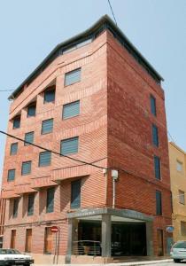 a tall red brick building on the corner of a street at Hotel Restaurante Salvadora in Villena