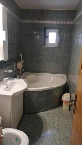 bagno con vasca e lavandino di NEVERSEA beachfront 2 bedroom apartament a Constanţa