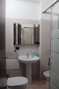 a bathroom with a sink and a toilet and a mirror at Il Belvedere vicino Taormina in Savoca