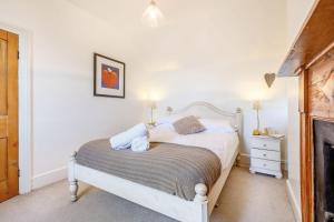 ein Schlafzimmer mit einem weißen Bett und einem Kamin in der Unterkunft Braich-Y-Celyn Lodge in Aberdyfi