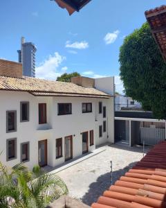 ein großes weißes Gebäude mit einem Dach in der Unterkunft Pousada Flor D' Açucena in Natal